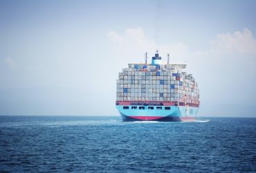 Container Ship Loaded With Cargo Containers Sailing On Sea Against Sky