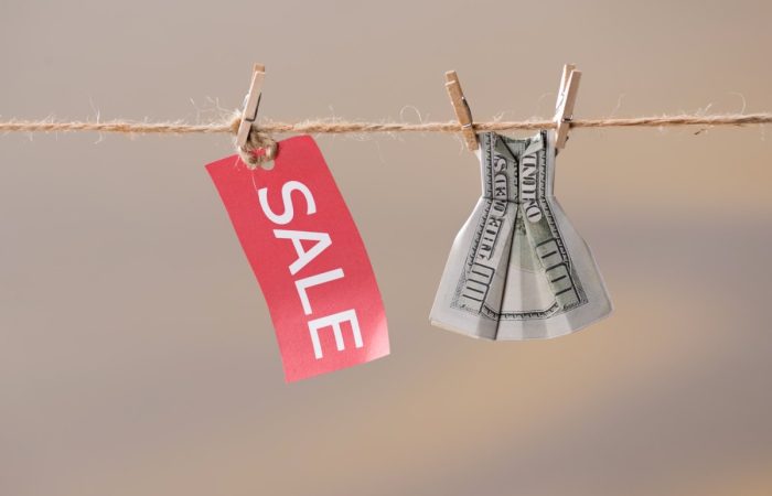 sale sign and one hundred us dollar banknote on clothesline, offer sale concept